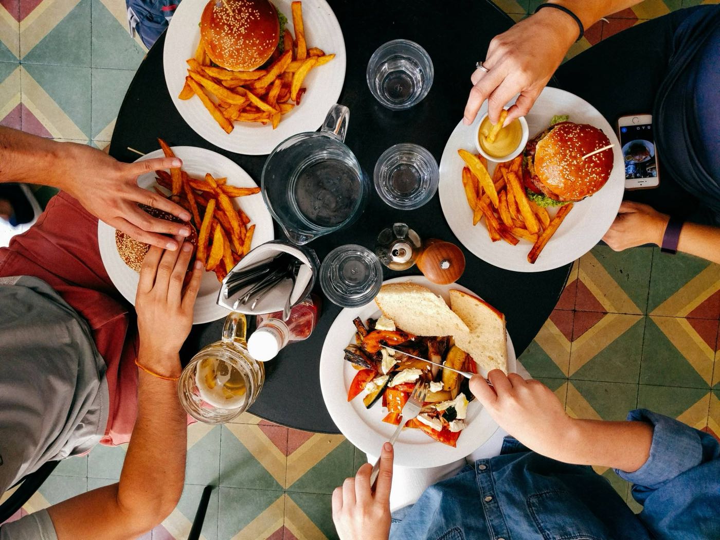 Un grupo de amigos comiendo en un restaurante, compartiendo platos en la mesa
